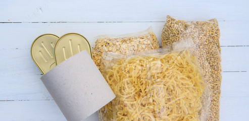 Coronavirus food donation.Cereals, toilet paper, canned food on a white background. Flat lay.charity