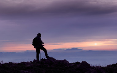 Obraz premium hiker on mountain peak at sunset