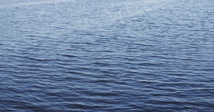 Slow motion shot of water ripples over a river or a lake.