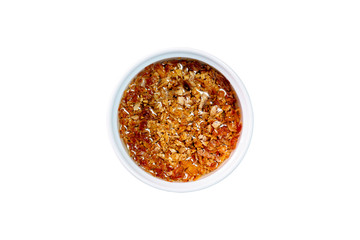 Fried garlic in vegetable oil in a white bowl on isolated white background. Top view.