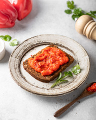 Balkan traditional pepper sauce ajvar, spread on rye bread