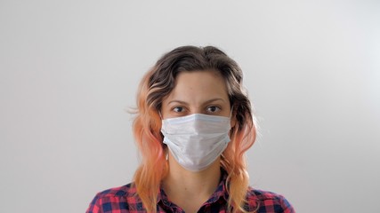 Portrait of a young woman in a white protective medical mask to prevent the spread of the virus during coronavirus or covid-19. Health care and medical concept. People, medicine, healthcare.