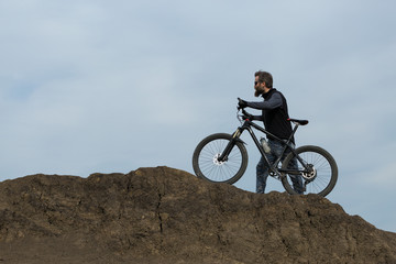 Plakat Sports brutal bearded guy on a modern mountain bike. Beautiful view from the mountain. Panoramic view for banner.