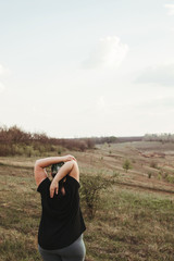 Overweight woman stretching hands relaxing while walking outdoors. Healthy lifestyle, weight loss, activity concept