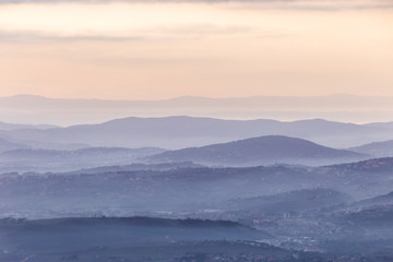 Obraz premium Sea of fog and mist between layers of mountains and hills at dusk