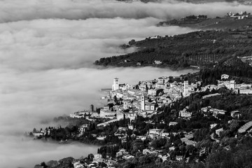 An aerial view of Assisi town and St.Francis church over a sea of fog