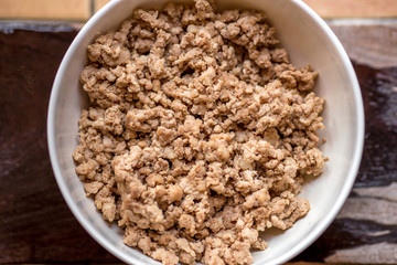 background of the cooked meat (minced pork) put in a clean container cup, for use as part of the food (noodle soup)