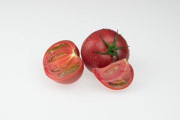fresh wet tomatoes on a white background. sliced tomatoes