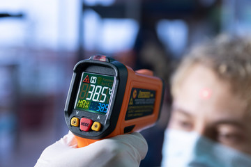 Laser infrared thermometer temperature control to an unidentifiable person showing high fever over 38 celsius