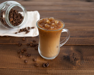 on a wooden table a glass of iced coffee