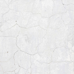 the white wall of an old house with beautiful cracks from time. white paint and whitewash on the wall. the background is white with soft blue and yellow. white old wall background