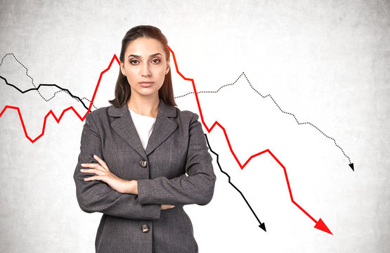 Serious young businesswoman, falling graphs