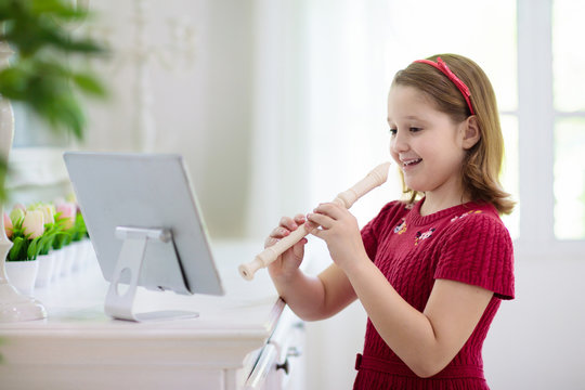 Child playing flute. Remote learning.