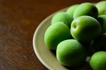 摘みたての梅の実。fresh plums on a old wooden table