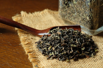 紅茶の茶葉とガラス瓶。tea leaves with a glass jar on a old wooden table