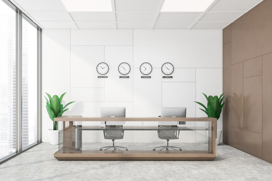 White and brown office with clocks and reception