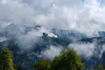 View through clouds and morning fog from Rantovse towards Skofja Loka hills