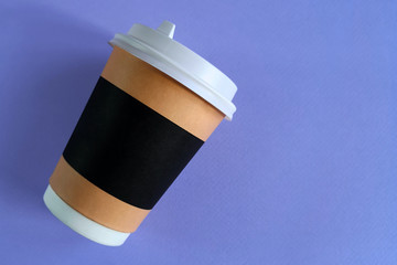 Mock up of paper cup on a light purple background. Top view of take-away cup with plastic lid. Space for a text