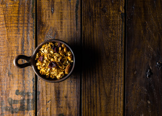 Granola in a clay pots with a beautiful wooden rustic background. Healthy concept. Vegan Concept. Copy space. Top view