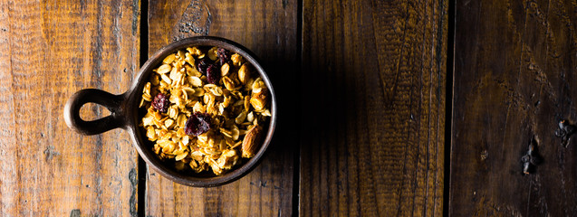 Granola in a clay pots with a beautiful wooden rustic background. Healthy concept. Vegan Concept. Copy space. Top view