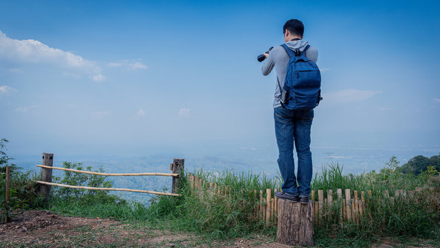 A man standing and taking pictures on the Don Mon Jam, Mae Rim, a tourist attraction in Chiang Mai, Thailand