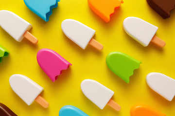 Fototapeta premium Colorful and various plastic toys ice cream with numbers for babies on a yellow background. Layout. Empty space for the text. Minimalism