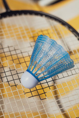 shuttlecock balls and badminton rackets on yellow and white striped background