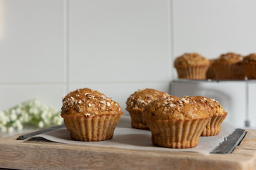 Fresh homemade delicious carrot muffins decorated with oat flakes and brown sugar on rustic table