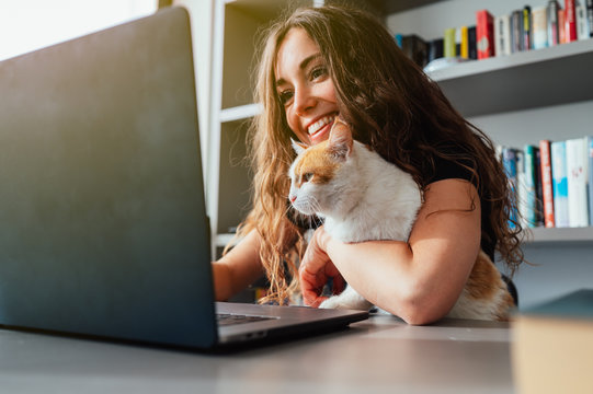 Giovane ragazza in smart woking con il gatto che le tiene compagnia 