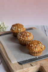 Fresh homemade delicious carrot muffins decorated with oat flakes and brown sugar on rustic table