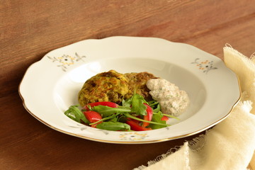 Lentil fritters with zucchini. Served with fresh vegetables and sauce