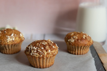 Fresh homemade delicious carrot muffins decorated with oat flakes and brown sugar on rustic table