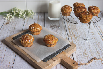 Fresh homemade delicious carrot muffins decorated with oat flakes and brown sugar on rustic table