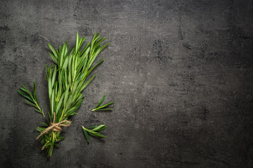 Rosemary sprig on a black kitchen table.