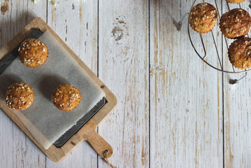 Fresh homemade delicious carrot muffins decorated with oat flakes and brown sugar on rustic table