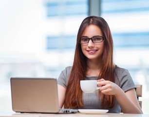 Young businesswoman drinking tea in office