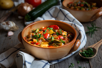 Chopped cooked vegetables on dark wood. Traditional ratatouille with zucchini, bell pepper and eggplant