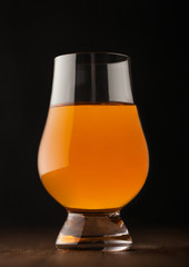 Single malt scotch whiskey in glencairn glass on wooden background