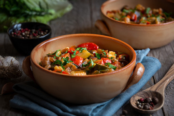 Chopped cooked vegetables on dark wood. Traditional ratatouille with zucchini, bell pepper and eggplant