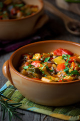 Chopped cooked vegetables on dark wood. Traditional ratatouille with zucchini, bell pepper and eggplant