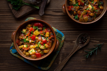 Chopped cooked vegetables on dark wood. Traditional ratatouille with zucchini, bell pepper and eggplant