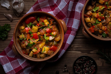 Chopped cooked vegetables on dark wood. Traditional ratatouille with zucchini, bell pepper and eggplant