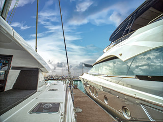 A luxury yatchs are berthing at  the jetty of yatch on sunset.