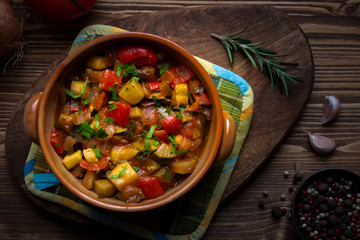 Chopped cooked vegetables on dark wood. Traditional ratatouille with zucchini, bell pepper and eggplant