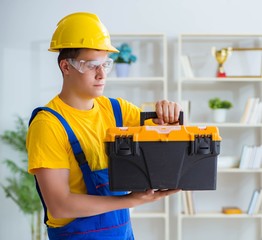 Young contractor doing repair works at office