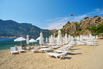 lonely white sunbeds and complicated umbrellas