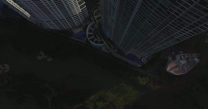 Back away aerial flight of high rise building tilting up revealing busy urban city skyline. Drone, 4K.