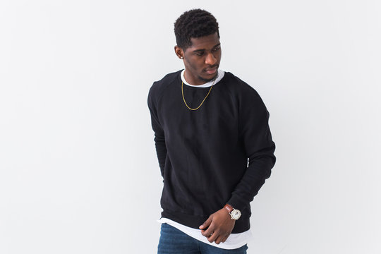 Street fashion concept - Studio shot of young handsome African man wearing sweatshirt against white background with copy space.