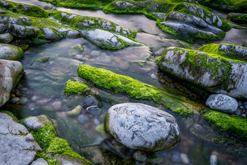 Long exposition of a river with rocks and moss