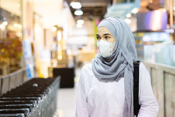 Asian muslim woman wearing medical mask for prevent dust and infection virus walking in the supermaket. Coronavirus(covid-19) concept.